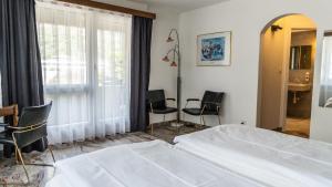 布里格的住宿－Hotel Europe Brig，一间卧室配有一张床铺、椅子和一张桌子