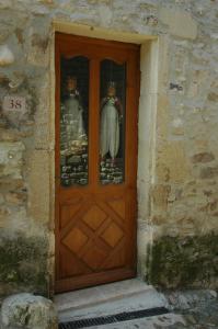 uma porta de madeira com duas estátuas em Annapurna Bed & Breakfast em Vaison-la-Romaine