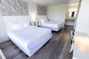 ein Hotelzimmer mit 2 Betten und einem Spiegel in der Unterkunft Oneway Savannah in Savannah