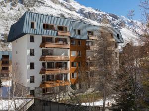 a apartment building with a snow covered mountain in the background at Appartement rénové avec wifi, garage et balcon sud à Val-d'Isère - FR-1-694-232 in Val dʼIsère