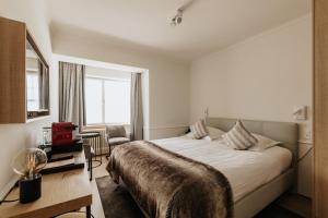 - une chambre avec un grand lit et une fenêtre dans l'établissement Marie Siska Boutique hotel, à Knokke-Heist