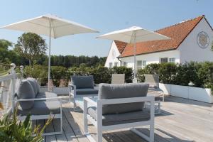 a patio with chairs and umbrellas on a deck at Marie Siska Boutique hotel in Knokke-Heist