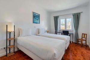 a hotel room with two beds and a window at Castle View in Setúbal