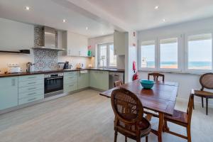 a kitchen with a wooden table and chairs in a room at Castle View in Setúbal