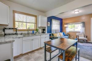 a kitchen with white cabinets and a table at Cozy Home with Backyard about 3 Mi to Downtown Saginaw! in Saginaw +16 photos