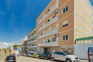 un edificio alto con auto parcheggiate in un parcheggio di Castle View a Setúbal