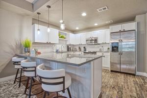 a kitchen with white cabinets and a large island with bar stools at 2 Bedroom townhome, super close to downtown FC! in Fort Collins