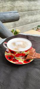 a cup of coffee on a plate on a table at Apartament u Danusi in Złoty Stok