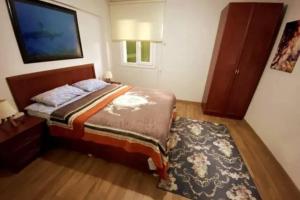 a bedroom with a bed and a tv and a rug at Duplex House in Kusadasi Marina Near Center in Kusadası