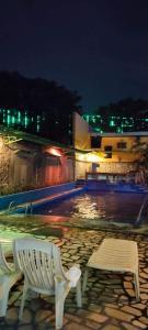um banco branco sentado ao lado de uma piscina à noite em 2 Hotel Saleh em Angeles