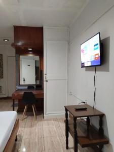 sala de estar con escritorio y TV en la pared en 2 Hotel Saleh en Ángeles