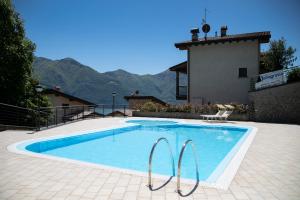 a swimming pool in front of a house at Fabula Home Rental - Casa Cuneo in Costa Volpino