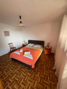 um quarto com uma cama com um cobertor laranja em MONTEFIN HOUSE em Petrovac na Moru