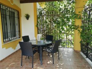 un patio con mesa, sillas y una valla en Casa el Olivo, en Mazarrón