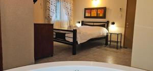 un dormitorio con una cama en una habitación en נופש דביר - צימרים מהממים למשפחות עם ג'קוזי ובריכה ליד הכנרת, en Migdal 15 fotos más