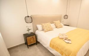 a bedroom with a bed with a pair of slippers on it at Amazing Old Town Penthouse II - EaW Homes in Marbella