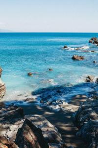 una vista del océano con rocas y el agua en Casa Familia, en Cabo Matapalo