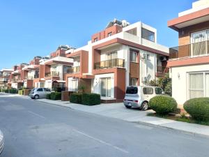 una fila de edificios de apartamentos con coches aparcados en una calle en Royal Sun NETFLIX Residence, Long Beach Design Apartment - no utility expenses! en Trikomo