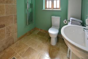 a bathroom with a tub and a toilet and a sink at The Old Parlour in Frome