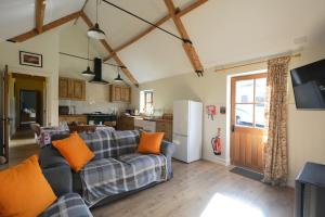 a living room with a couch and a kitchen at The Old Parlour in Frome