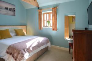a blue bedroom with a bed and a window at The Old Parlour in Frome