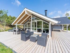 een houten terras met stoelen en tafels erop bij Holiday home Nørre Nebel CXXV in Nørre Nebel