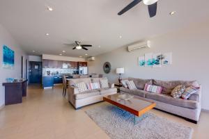 ein Wohnzimmer mit einem Sofa und einem Tisch in der Unterkunft Cabo Pedregal Condo Ocean View and 2 Infinity Pools in Cabo San Lucas