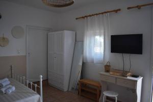 1 dormitorio con 1 cama y escritorio con TV en Cantera house, Kalokairines KIT en Kýthira