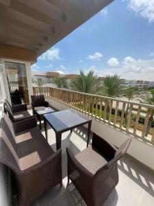 a balcony with chairs and a table on a balcony at Almaza Bay Beach Town Chalet in Marsa Matruh
