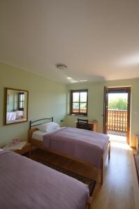 a bedroom with two beds and a balcony at Hostel Strug in Makole