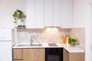 a kitchen with white cabinets and a sink at Lulu Suites - Moka in Golem