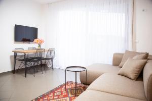 a living room with a couch and a table at Lulu Suites - Moka in Golem