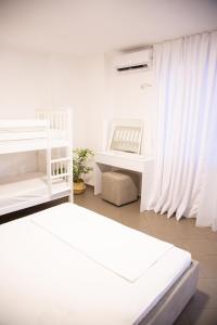 a white room with two beds and a desk at Lulu Suites - Moka in Golem