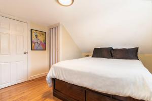 a bedroom with a large bed with white sheets at Pet-Friendly Cranston Home with Fire Pit and BBQ! in Cranston