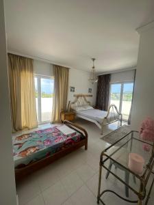 a bedroom with two beds and a glass table at Paradiso Kallithea villa in Koskinou