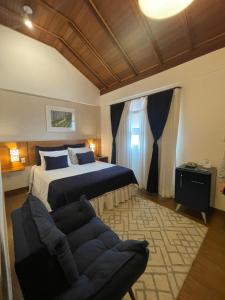 a bedroom with a king sized bed and a couch at Hotel Aromas de Penedo in Penedo