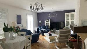 a living room with a chandelier and a table and chairs at Chambres Quiétude in Chavanoz