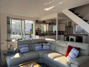 a living room with a gray couch with blue and red pillows at Beachfront retreat apartment with amazing terrace in Hastings