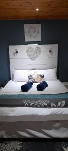 a bedroom with a white bed with a heart headboard at Rest and Rise in Pietermaritzburg