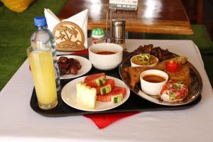 bandeja con platos de comida y un vaso de zumo de naranja en SKYZ9 HOTEL, en Kakamega