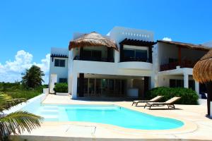 a large house with a swimming pool in front of it at Villa Samotracia in Uaymitun