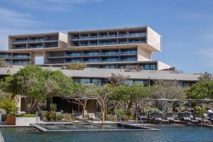 a building with chairs and a pool in front of it at The Club at Solaz Luxury Villas in San José del Cabo