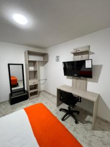 a bedroom with a desk with a computer and a monitor at Hotel Villa Maria Uribia in Uribia