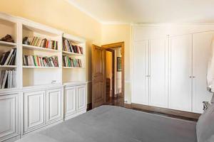 sypialnia z białymi szafkami i półkami na książki w obiekcie Rome villa swimming pool w mieście Campagnano di Roma