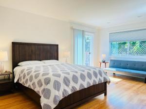 1 dormitorio con 1 cama grande y 1 sofá azul en 3 bedroom residential home in the lovely town near SFO San Francisco en Millbrae