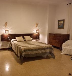 - une chambre avec un grand lit et deux lampes dans l'établissement L'Escala - Pintor Massanet, à L'Escala