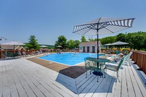 - une piscine avec une table et un parasol dans l'établissement Branson Condo with Lake Access and Resort Amenities!, à Branson