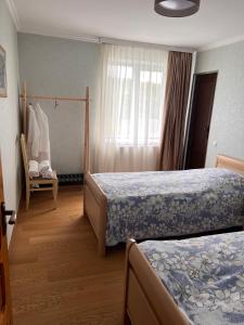 a hotel room with two beds and a chair at Brewery House&Beer Spa in Aspindza