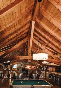una mesa de billar en una habitación con techos de madera en Heather Mountain Lodge, en Golden