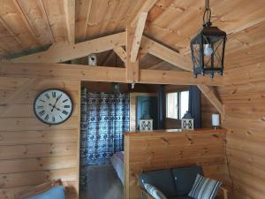 a living room with a clock on the wall at La Grange et Le Nid in Biscarrosse